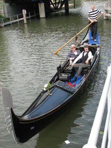 878146 Afbeelding van een gondel die gaat aanmeren aan de Nieuwekade in Wijk C, waar een gemeentelijk uitlegbord ...